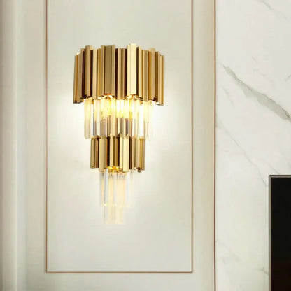 Modern gold and clear glass led wall lamps featuring gold-toned tiered bars with hanging crystal accents for bedroom use