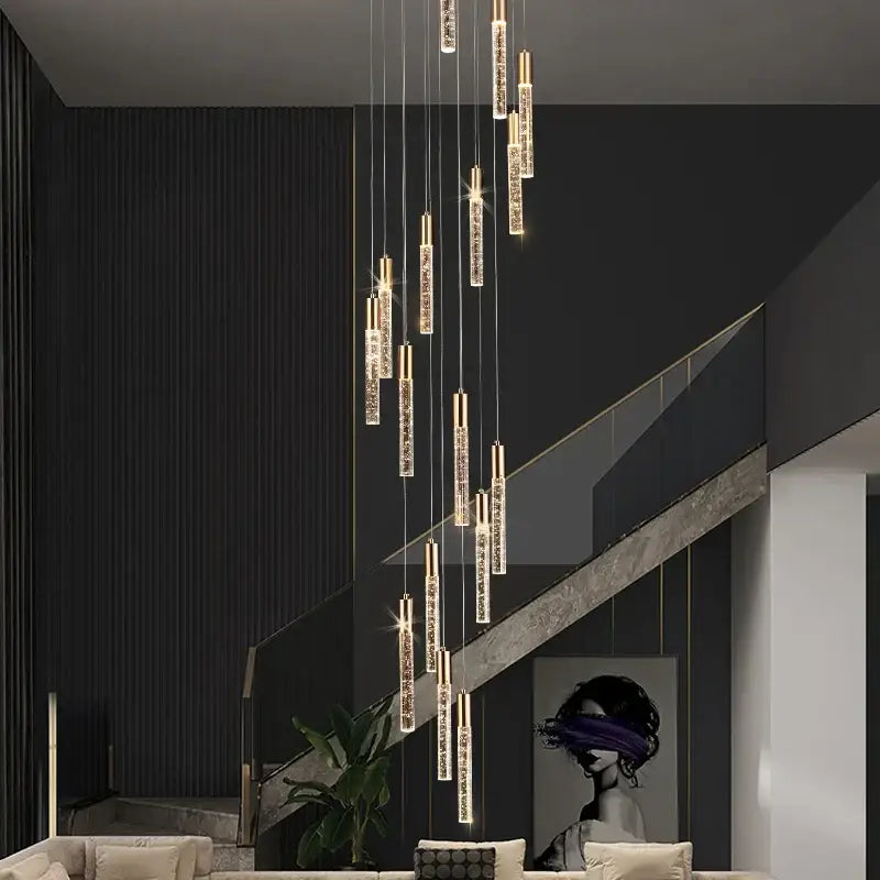Modern gold and crystal cylindrical stair chandelier with vertical crystal rods and warm light by decorbites cylindrical stair