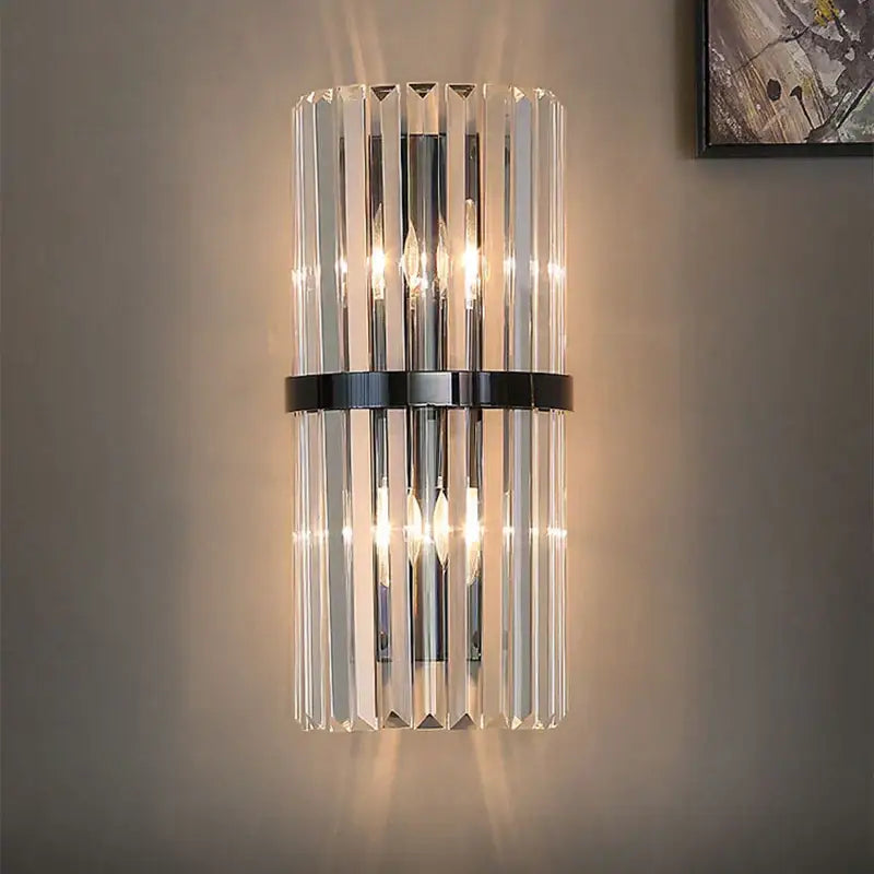 Modern gold and crystal wall light featuring vertical crystal prisms and a polished gold-toned metal band decorbites crystal wall