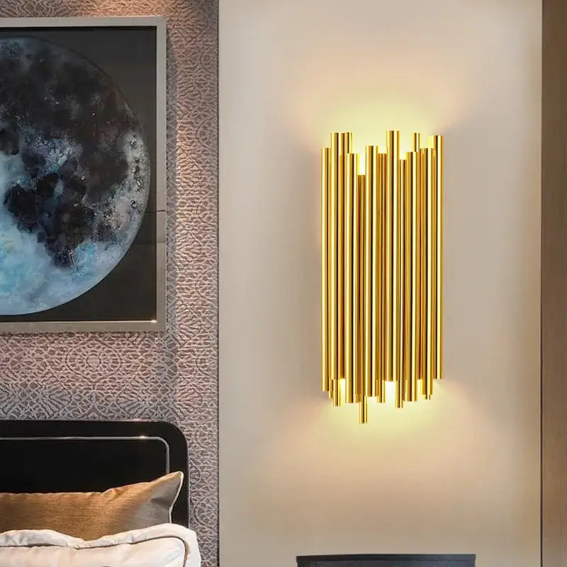 Modern gold and glass led wall lamps featuring vertical cylindrical tubes emitting warm glow for bedroom use
