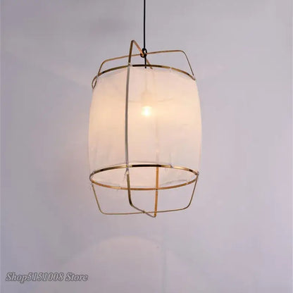 Modern gold and glass pendant light fixture with brass wireframe and bamboo linen shade for dining room decorbites
