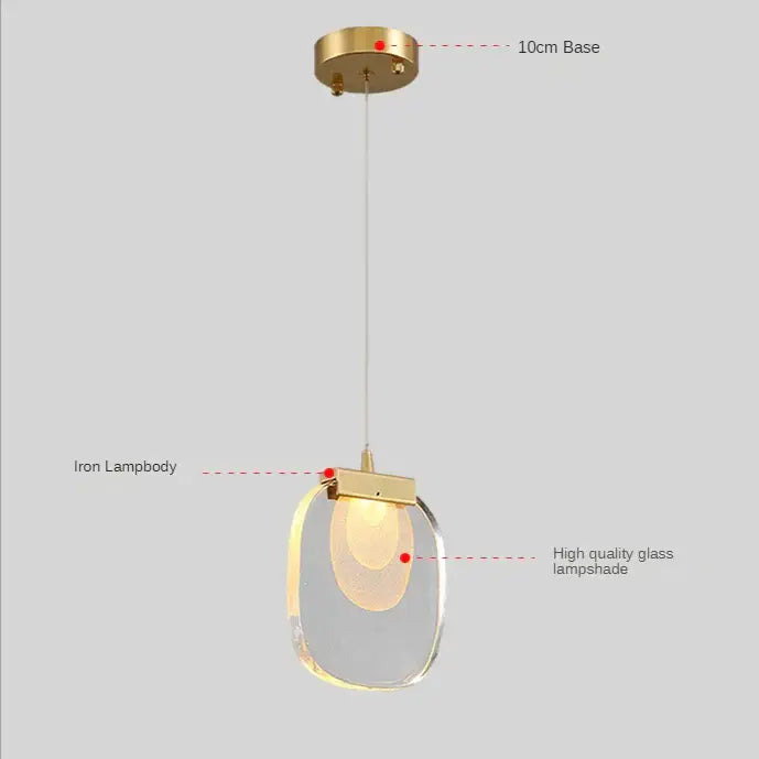 Modern gold and glass pendant lights featuring a brass-finished iron lampbody and clear glass pendant for dining room