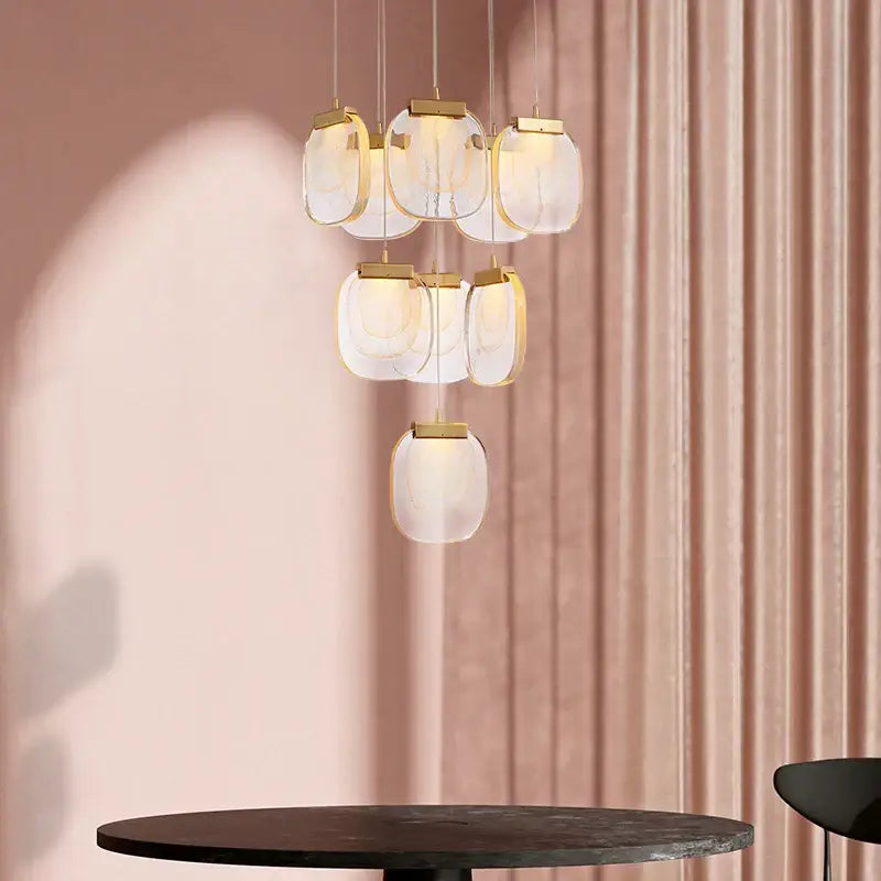 Modern gold and glass pendant lights with multiple frosted glass globes for elegant dining room lighting