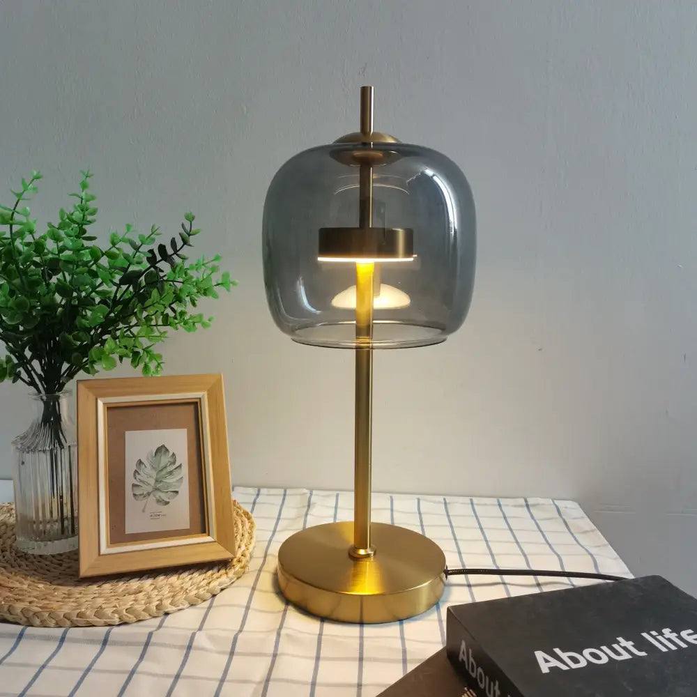 Modern gold and gray glass table lamp set featuring brass finish and rounded smoked glass shade for bedroom use