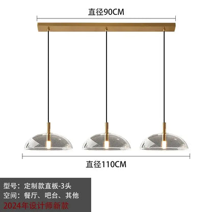 Modern gold pendant light with brass bar and clear dome glass pendant shades featuring intricate mesh pattern for kitchen