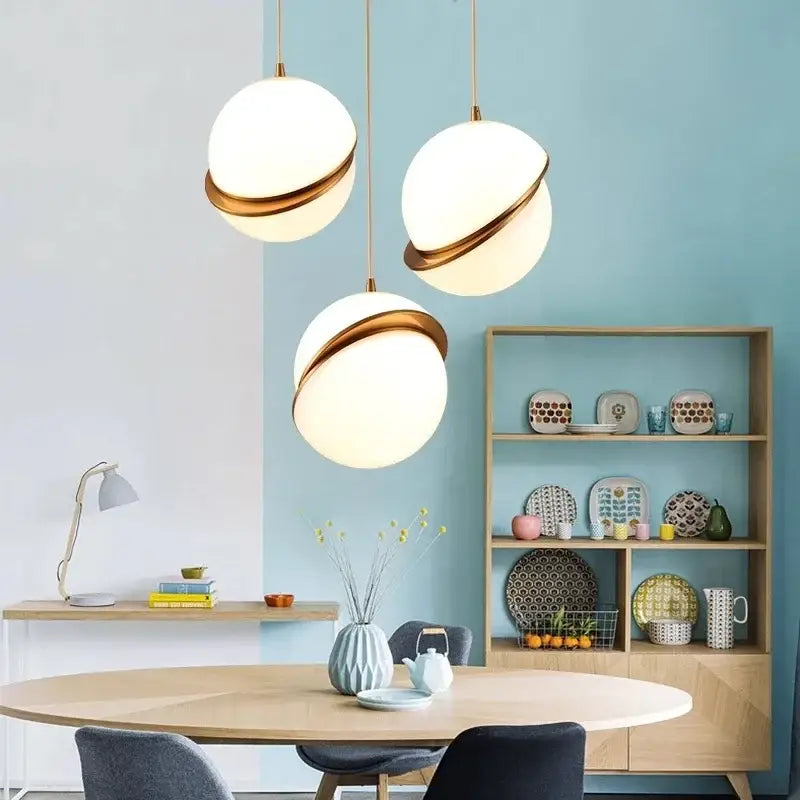 Three modern pendant lights with spherical white glass and gold-toned rings decorbites golden ball pendant light