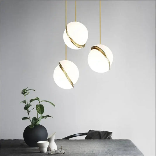 Three modern pendant lights with white frosted glass spheres and gold-toned rings for dining room chandelier decorbites golden ball pendant