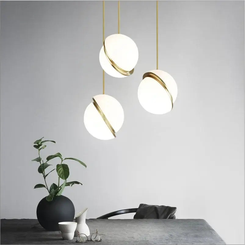 Three modern pendant lights with white frosted glass spheres and gold-toned rings for dining room chandelier decorbites golden ball pendant