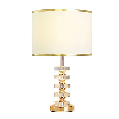 Modern gold and white crystal table lamp with cream fabric shade and stacked crystal rings base for bedroom decorbites decor