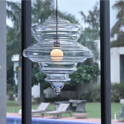 Modern gold and white decorbites glass chandelier featuring a clear glass pendant light with tiered ribbed design and warm bulb