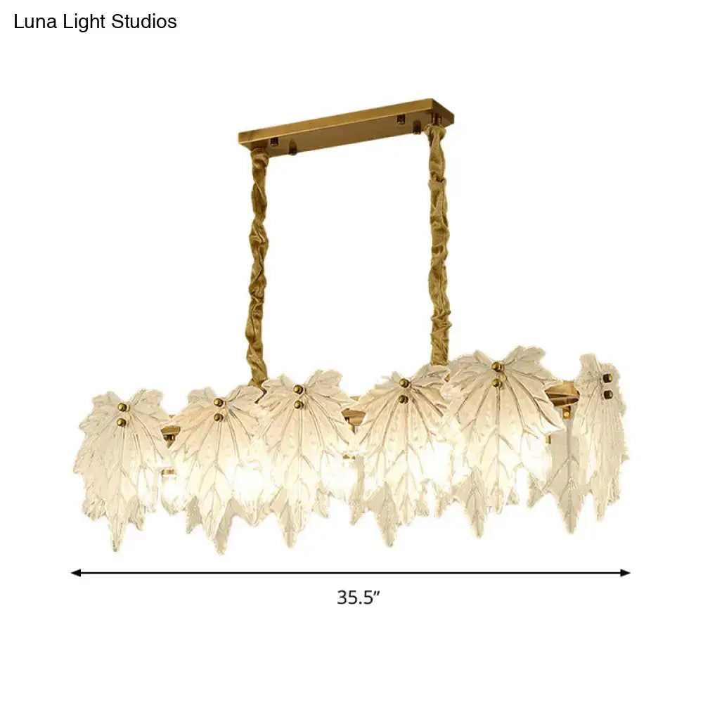 Elegant modern gold pendant light fixture with white glass leaf-shaped shades suspended by twisted brass chains