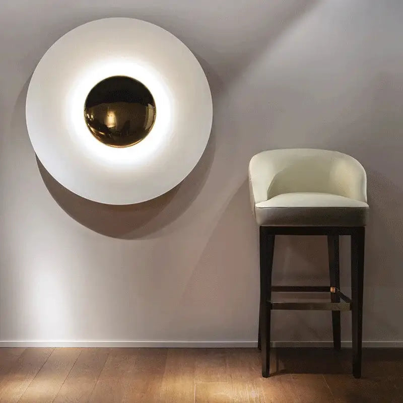 A modern gold and white led ufo wall sconce with a polished spherical center for wall sconces bedside lighting
