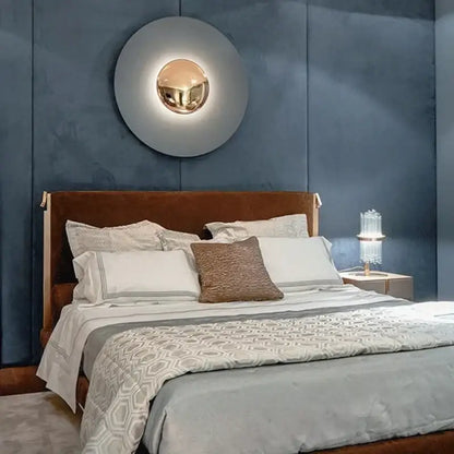 A modern gold and white led ufo wall sconce with a polished gold center and matte gray outer ring for bedroom ambiance