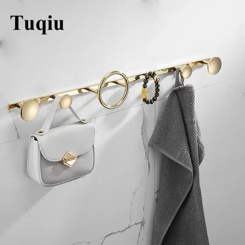 Modern gold and black brass towel hook set with sleek circular and oval wall-mounted hooks for bathroom use