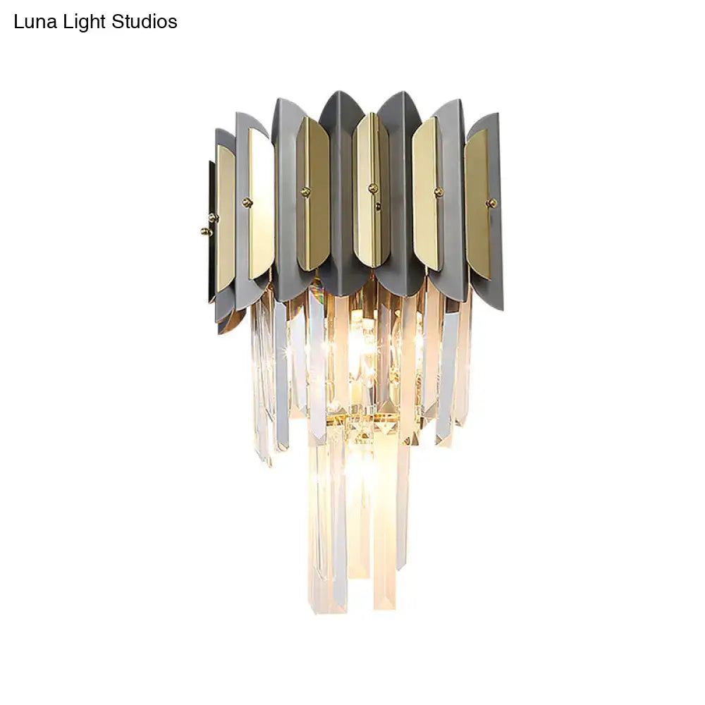 Modern gold and black sconce light fixture with metallic leaf plates and cascading crystal prisms for bedroom walls