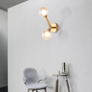 Gold-toned modern wall lamp with double globe glass bulbs designed as a corridor sconce light fixture