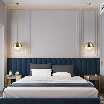 Deep blue tufted velvet headboard with matching bed skirt and panels under modern gold and black decorbites glass ball led pendant light