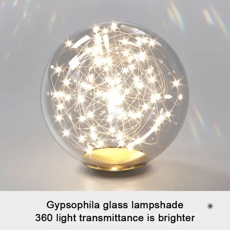 Modern pendant light with clear glass globe, golden wireframe, embedded fairy lights, gold base, and selectable light colors