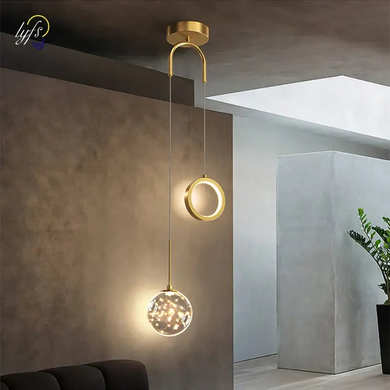 Modern gold pendant light with black glass globe and warm led lights featuring selectable light colors for dining rooms