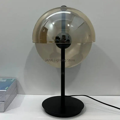 Modern floor lamp with sleek black metal base and translucent amber decorbites glass hemisphere led dome