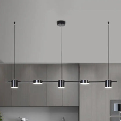 Modern black metal pendant light fixture with four cylindrical bulbs on a sleek bar emitting warm white light
