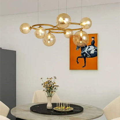 Modern gold black magic bean ceiling chandelier with amber glass globe bulbs suspended by thin wires for dining room