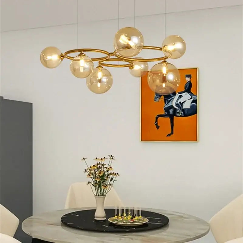 Modern gold black magic bean ceiling chandelier with amber glass globe bulbs suspended by thin wires for dining room