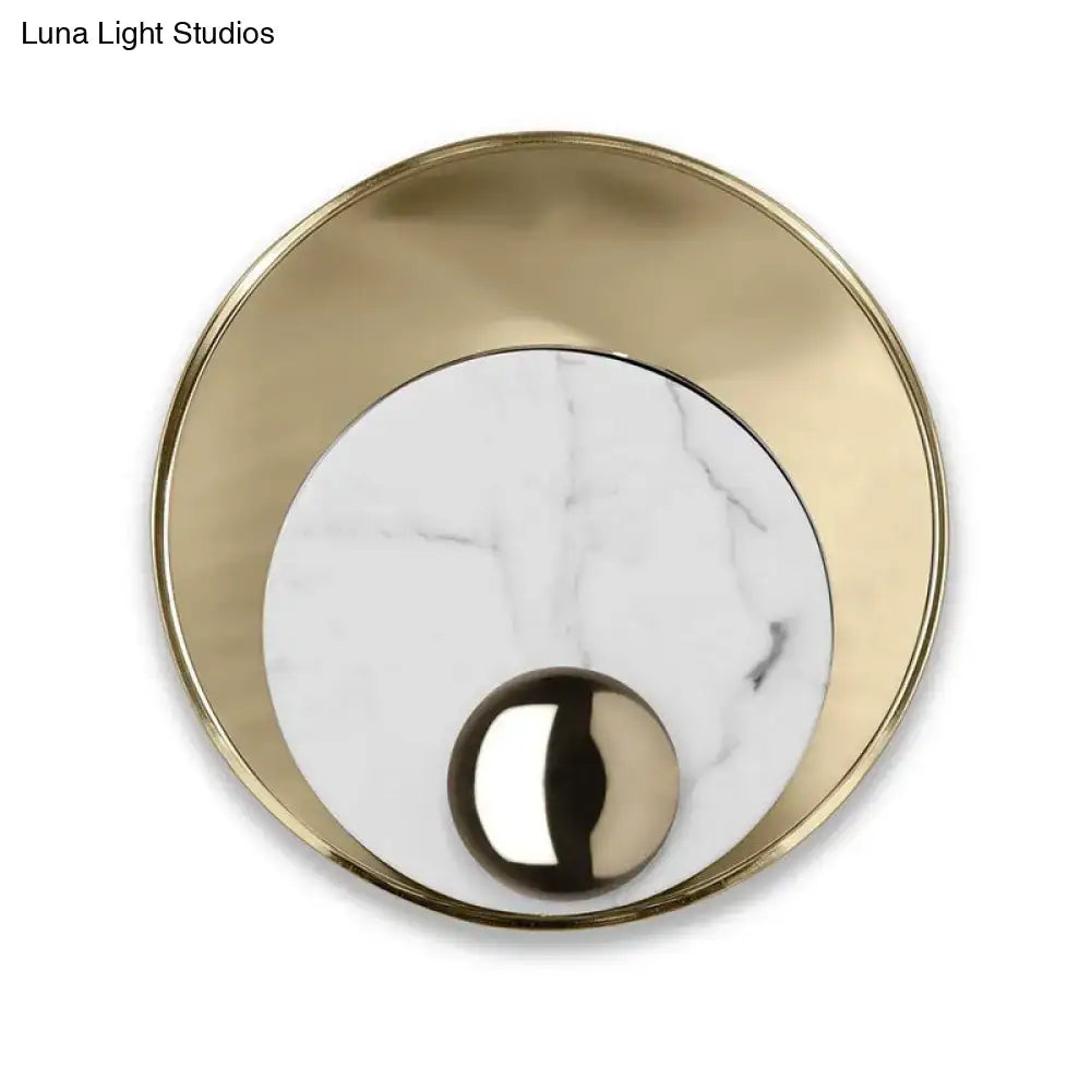 Modern gold and black marble wall sconce with brushed gold frame white marble center and peacock tail feather design