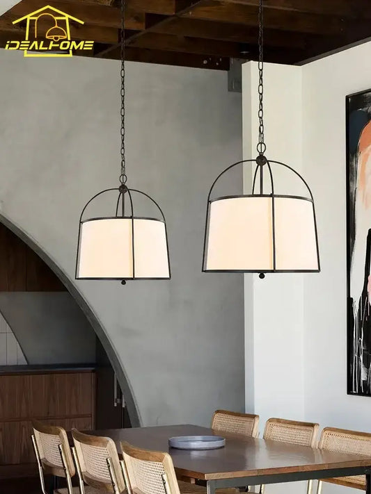 Modern gold black pendant lights with fabric shades and chains hang above a wooden dining table decorbites gold black pendant