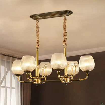 Modern gold and black ribbed glass island chandelier with six textured glass shades and twisted rope chains
