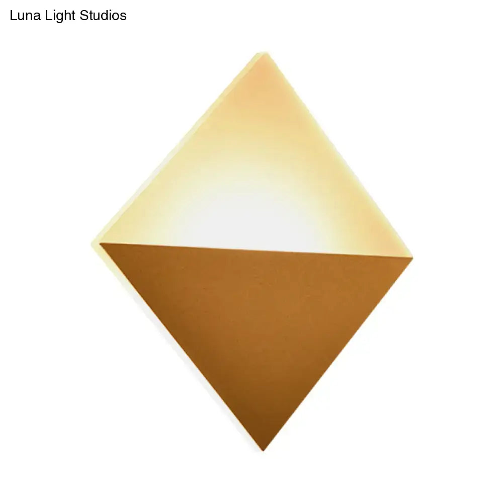 Modern gold and black wall sconce with diamond shape, warm glowing upper half, matte bronze lower half, fixture height ideal for bedroom use