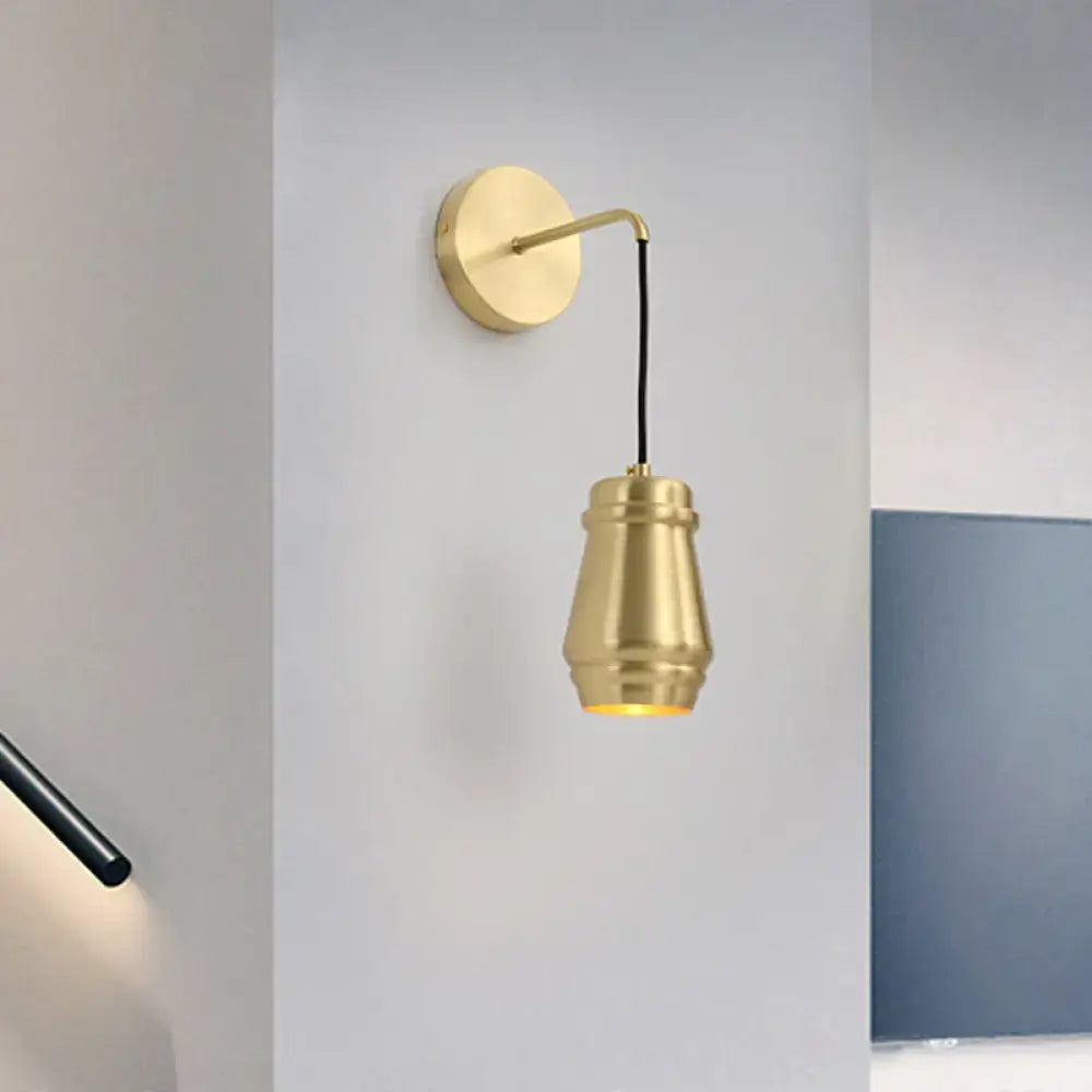 Modern gold brass bedroom wall sconce with metal shade and sleek curved arm inch fixture for stylish lighting