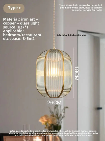 Modern gold brass glass restaurant light featuring a cylindrical glass shade with copper bars and warm ambient lighting