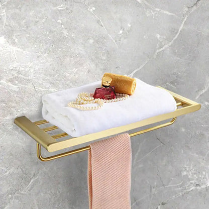 Modern gold brushed bathroom accessories set featuring a gold-toned metal towel rack holding white and pink towels decorbites bathroom