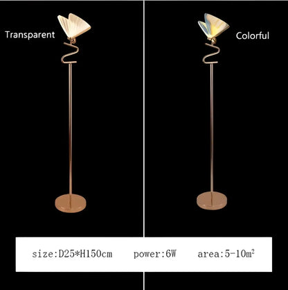 A slender gold-toned metal floor lamp with a curved base and butterfly led pendant emitting soft light decorbites butterfly led