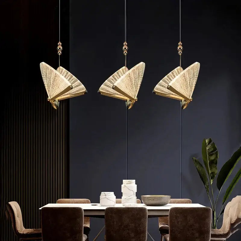 Three elegant gold-toned decorbites butterfly pendant lights with intricate woven mesh detail for luxury bedroom lighting