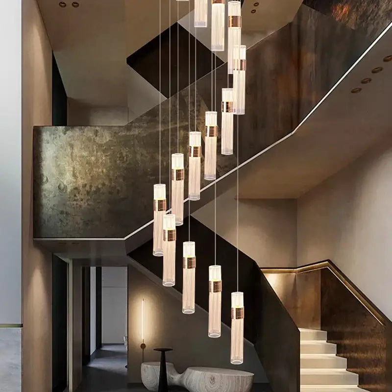 Modern gold cascading pendant light with cylindrical glass shades brass accents and adjustable height for dining room