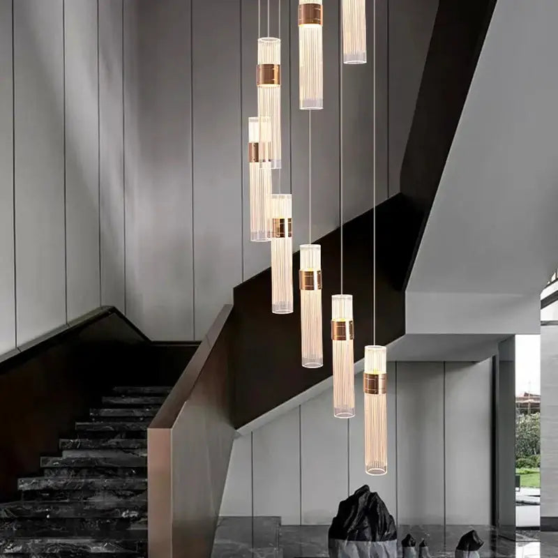 Modern gold cascading pendant light with frosted glass shades and brass accents features adjustable height design