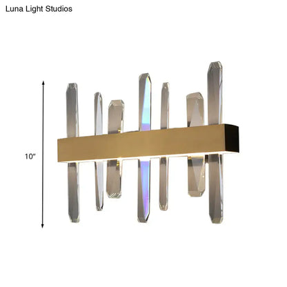 Modern gold clear crystal bar wall sconce with sleek rectangular base and vertical clear crystal prisms refracting colorful light