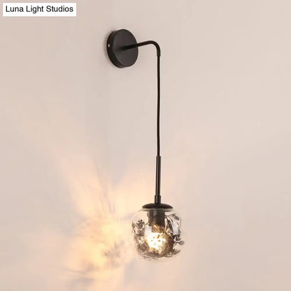 Black metal wall light with clear glass spherical globe featuring delicate flower deco cloth etchings for bedroom decor