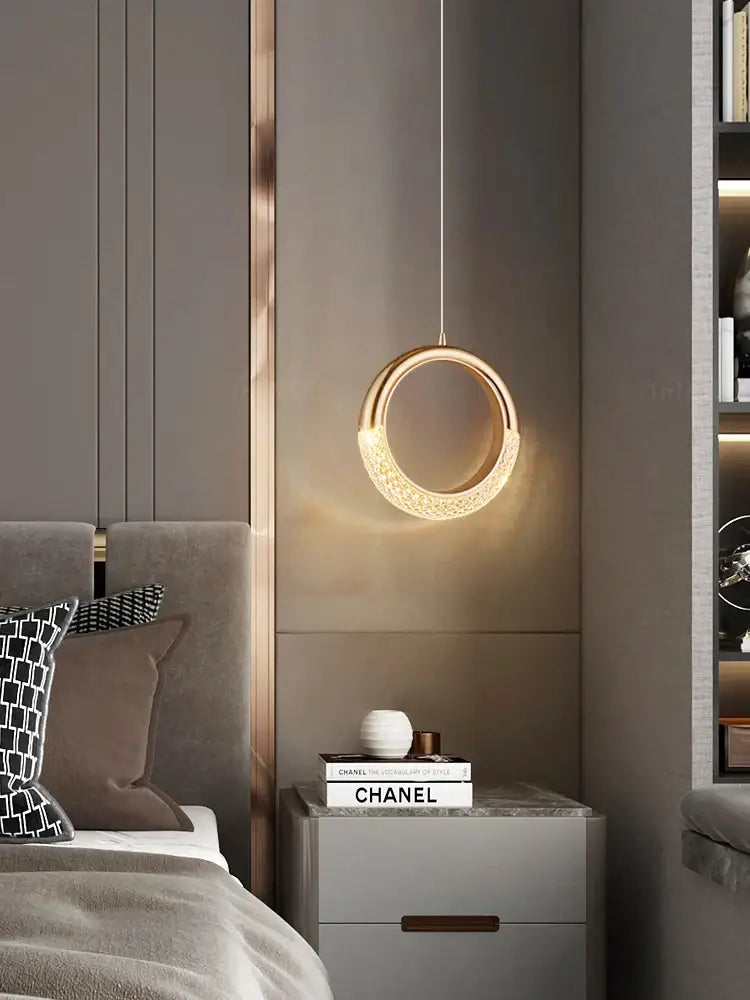 A modern gold crescent pendant light made of high-quality French metal with a textured surface for dining settings