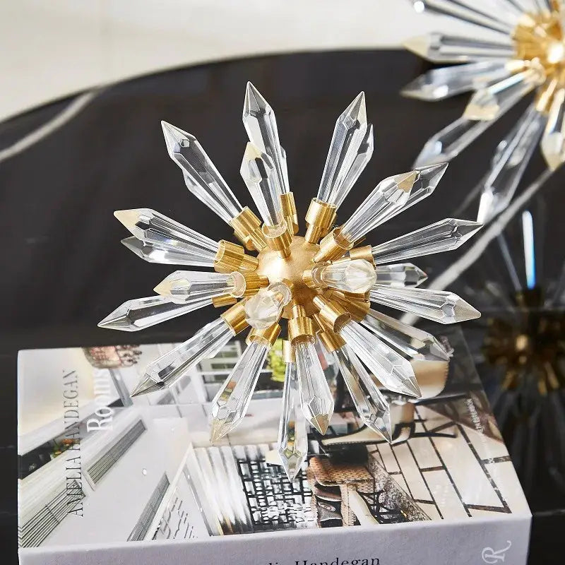 A modern gold crystal ball acanthosphere home decoration with a radiant starburst-shaped clear faceted crystal decorbites crystal ball