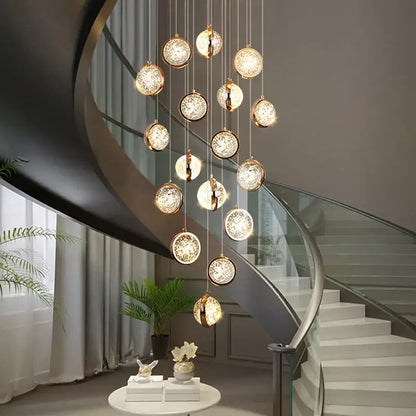 Modern gold crystal ball chandelier with crystal accents hanging above a staircase as a ball chandelier lighting
