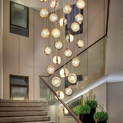 Modern gold crystal ball chandelier with spherical glass orbs suspended in a staircase setting ball chandelier