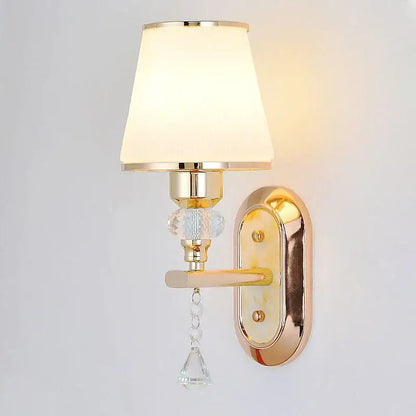 Modern gold crystal bedside wall sconce with cream fabric shade and clear glass bead accents for bedroom lighting