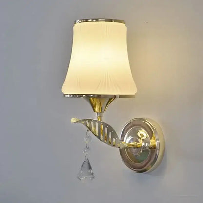 Modern gold crystal bedside wall sconce with brass finish, cream fabric shade, and dangling crystal accents for bedroom decorbites crystal bedside