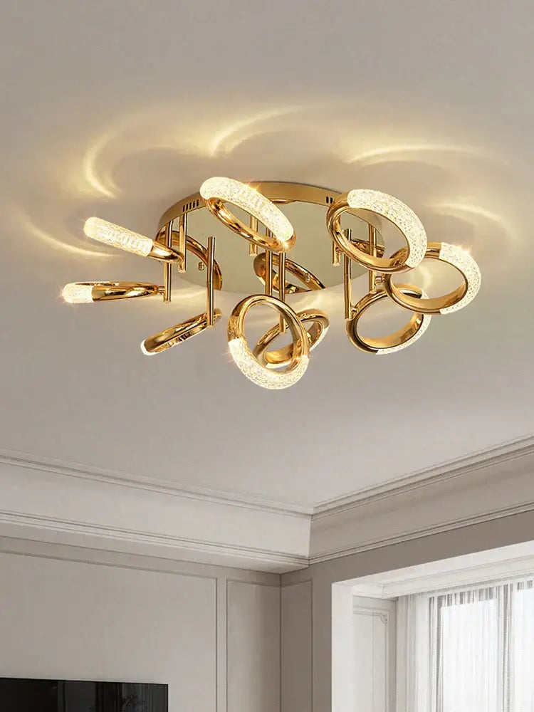 Modern gold-toned ceiling light with interlocking circle ring led design and frosted glass accents for bedroom use