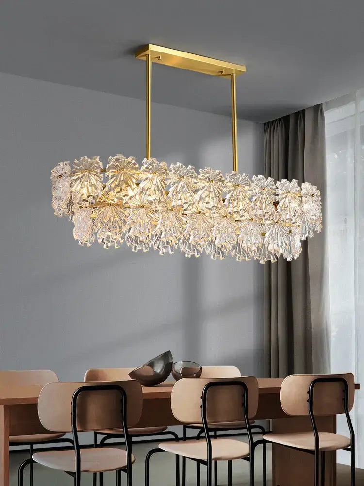A modern gold glass led pendant light with rectangular metal frame and floral crystal design for dining room