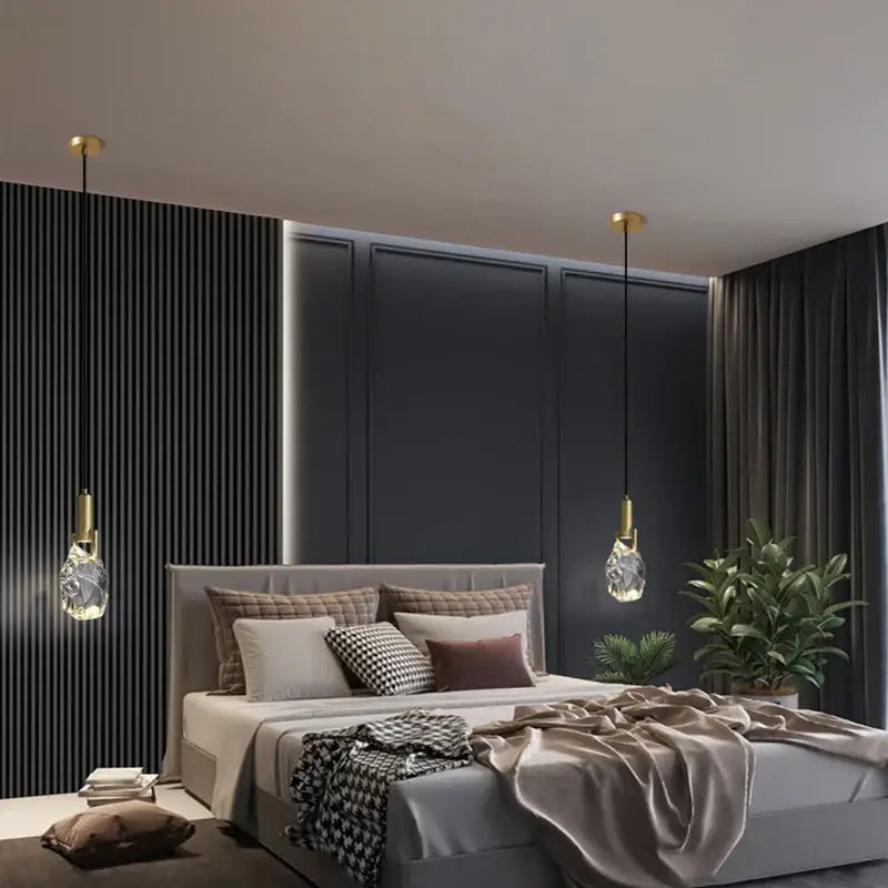 Two elegant gold crystal iron bedside chandelier pendant lights with faceted glass shades hang symmetrically from ceiling
