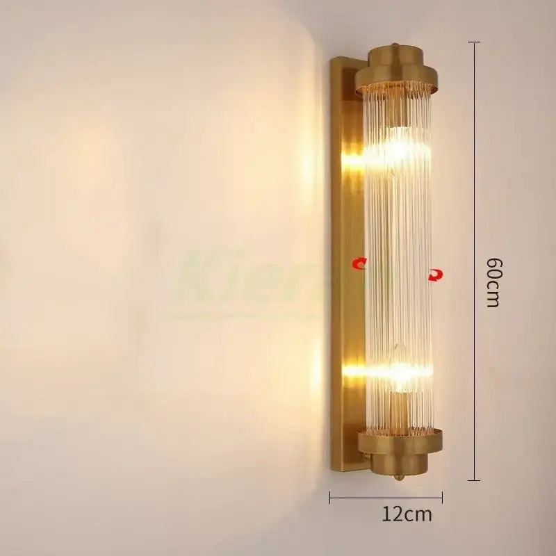 Modern gold crystal led wall lamp with brass finish and vertical glass rods emitting warm glowing light decorbites crystal led wall
